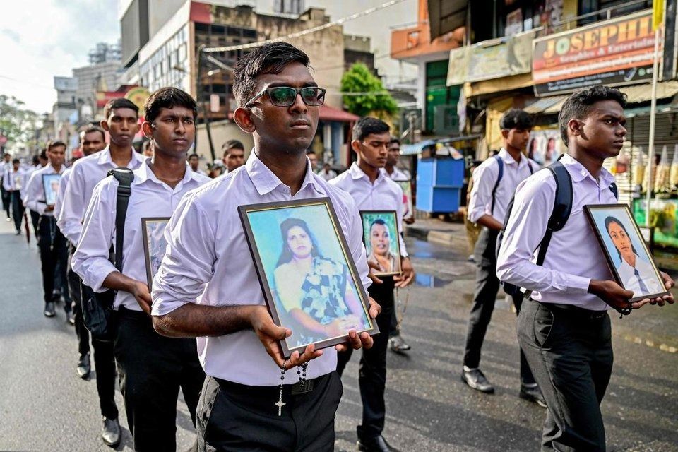Men carrying portraits of victims of the 2019 Easter Sunday bombings as they mark the sixth anniversary of the attacks in Colombo on April 21. - Photo: AFP