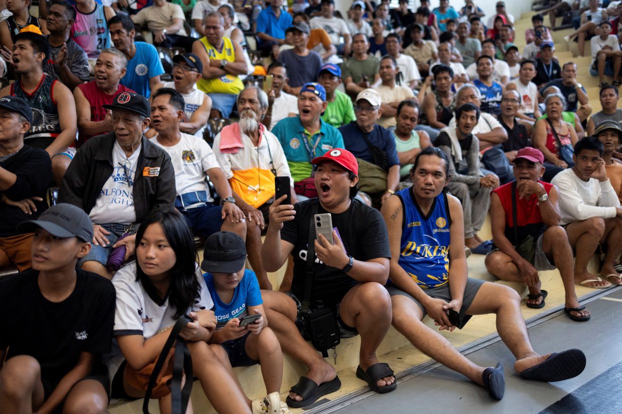 Filipino boxing fans react while watching a livestream of the WBC welterweight fight between Philippine boxing icon and former senator Manny Pacquiao and WBC welterweight champion Mario Barrios, at a school gym in Mandaluyong City, Philippines, Sunday, July 20, 2025. -- Photo: REUTERS/Eloisa Lopez