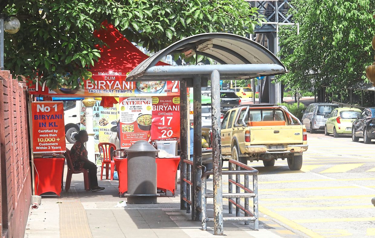 A briyani stall behind a bus stop in Jalan Sultan Abdul Samad, blocking pedestrian access. It poses a hazard for commuters trying to board or exit buses.