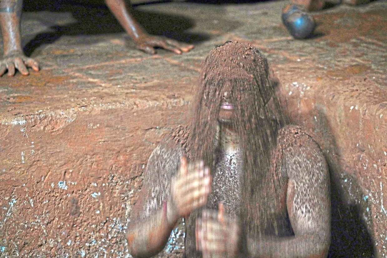 A wrestler showering himself with mud from the wrestling pit after training at the Shree Shahu Vijayi Gangavesh Talim, a residential gymnasium in Kolhapur, Maharashtra state. — AFP