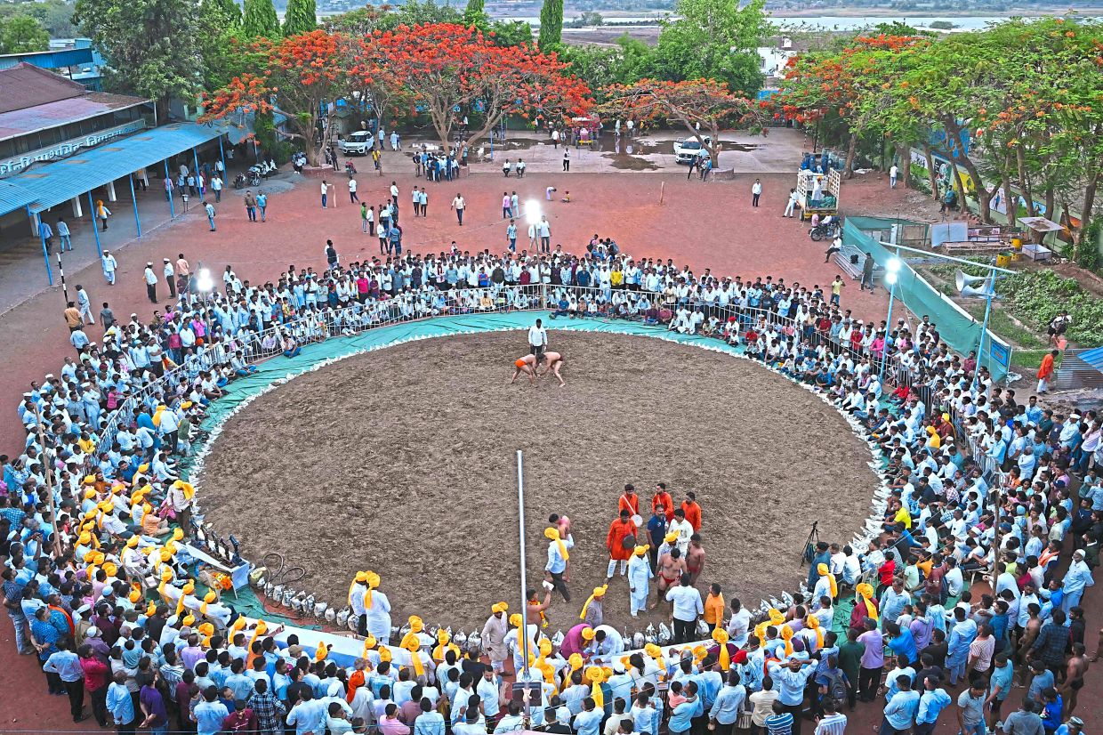 Spectators watching a bout of wrestling during a competition in Shirwal in the Satara district of Maharashtra state. This style of wrestling, known as ‘kushti’ or ‘dangal’, has millenia-old roots, but it emerged during the period of India’s Mughal rulers in the 16th century, blending traditional hand-to-hand combat with Persian martial arts. — AFP