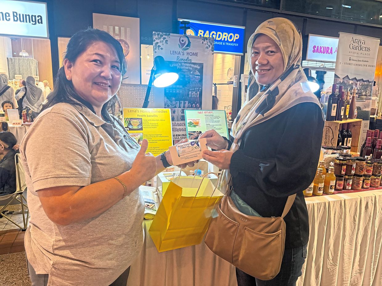 Lena with a Bruneian customer, purchasing her home made tea.