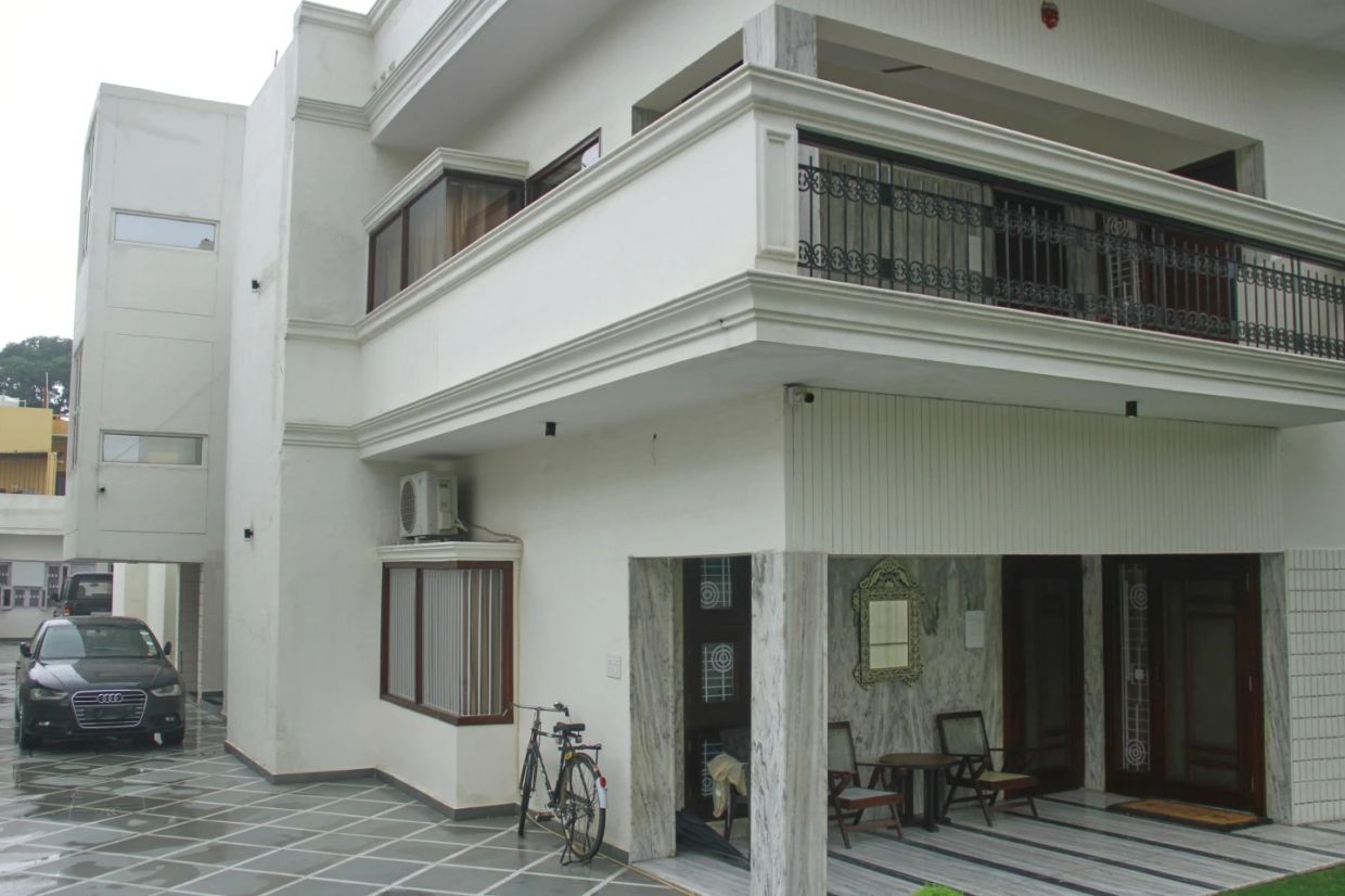 A luxury car and a bicycle are seen parked outside a rented residential building in which a bogus embassy was running in Ghaziabad, outskirts of New Delhi, India, Wednesday, July 23, 2025. - Photo: AP