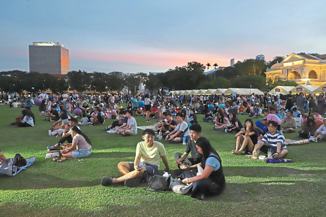 The crowd on the Esplanade field enjoying food while taking in stage performances.