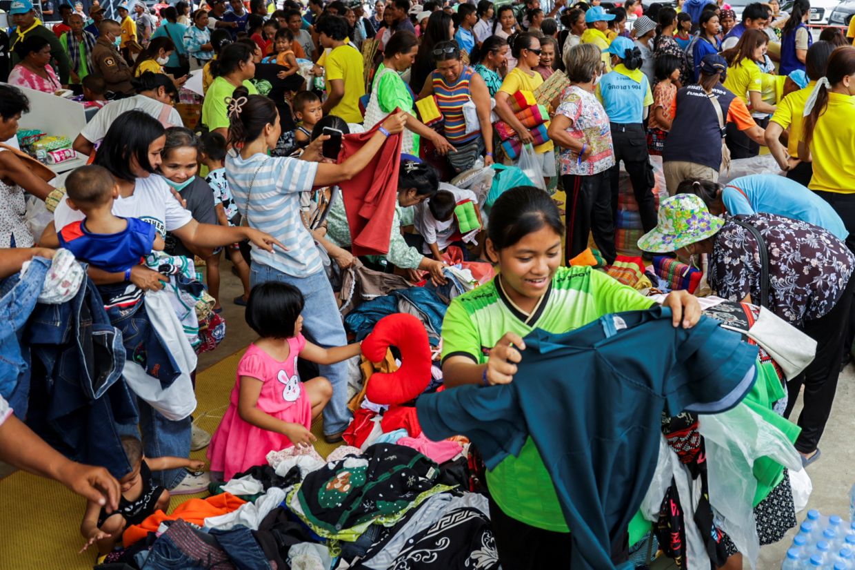 People search for clothes at a pile of donated items at a shelter, following recent clashes along the disputed border between the two countries. According to authorities, people have been killed across three border provinces, in Buriram province, Thailand, on Thursday, July 24, 2025. -- Photo: REUTERS/Prajoub Sukprom