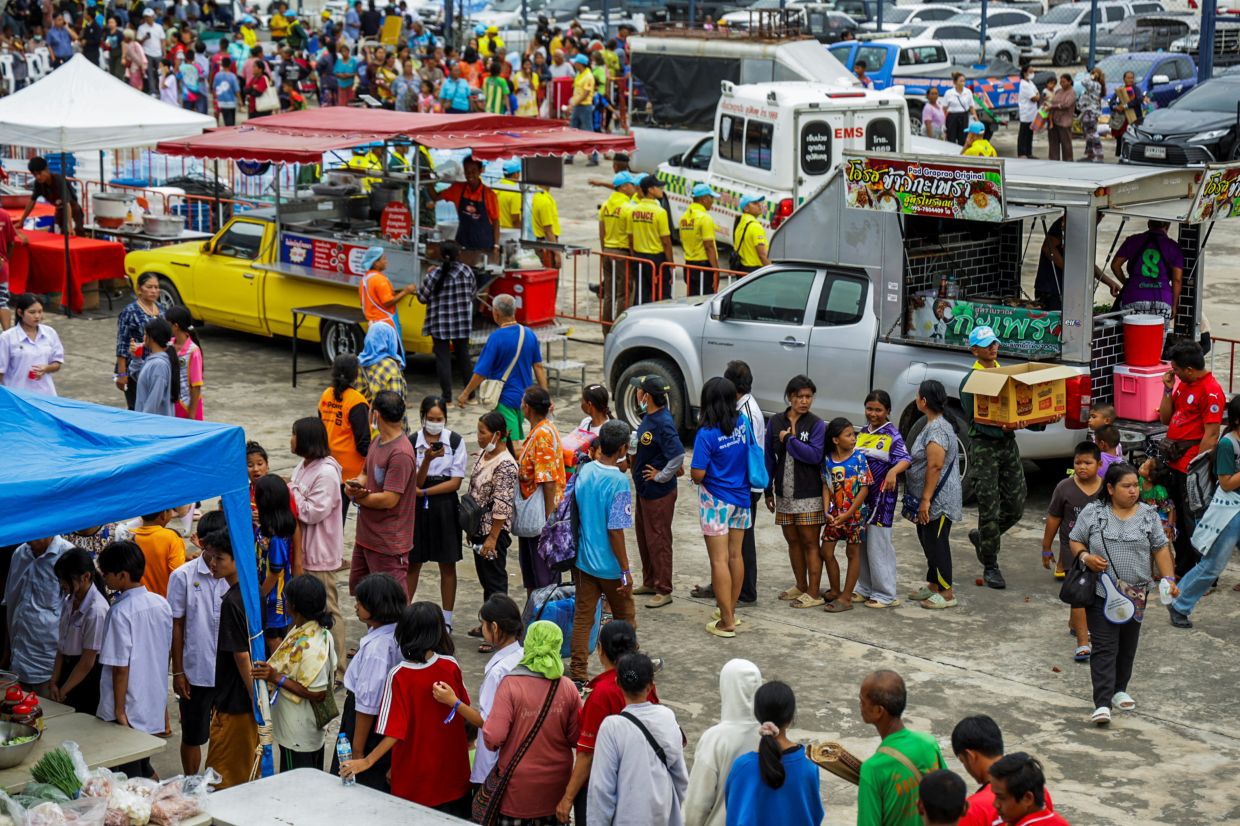 People wait in line to get food at a shelter, following recent clashes along the disputed border between the two countries. According to authorities, people have been killed across three border provinces, in Buriram province, Thailand, on Thursday, July 24, 2025. -- Photo: REUTERS/Prajoub Sukprom