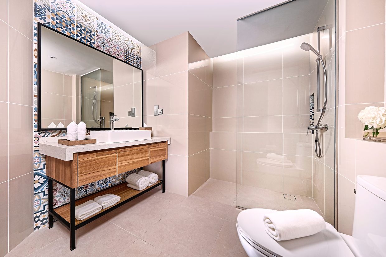 Bathrooms featuring Peranakan-inspired tiles add a touch of local heritage to the modern design.
