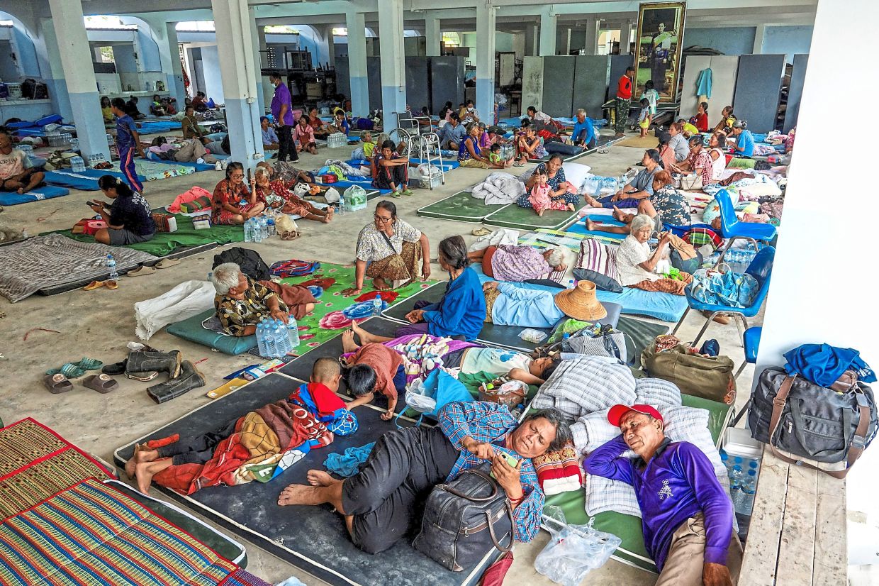 People resting at a shelter following recent clashes along the disputed border between the two countries in Surin province. — Agencies
