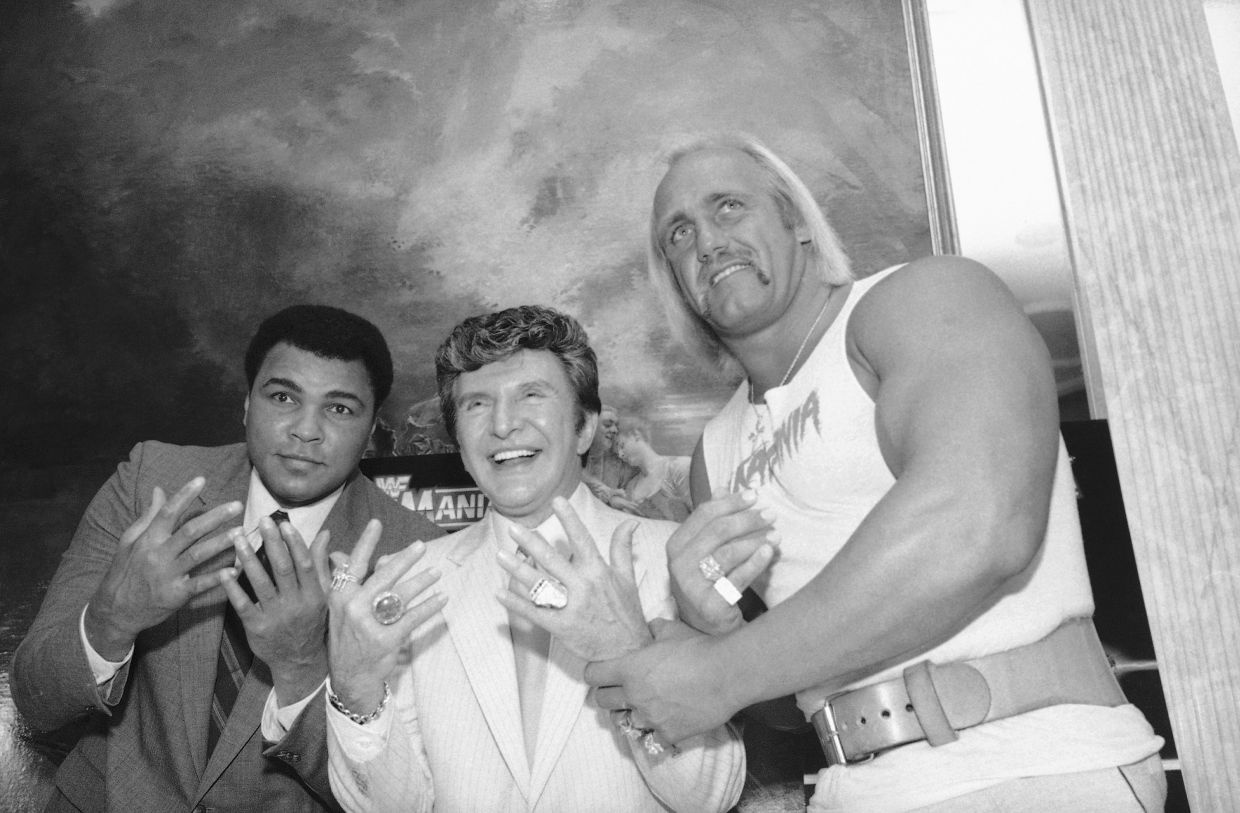 Muhammad Ali, left, Liberace, center, and Hulk Hogan get together at Madison Square Garden in preparation for their upcoming wrestling event, March 29, 1985, in New York. Ali was guest referee and Liberace time keeper when Hulk Hogan and Mr. T, of A-Team fame, were pitted against Rowdy Roddy Piper and Paul (Mr. Wonderful) Orndorff. (AP Photo/Marty Lederhandler, File)