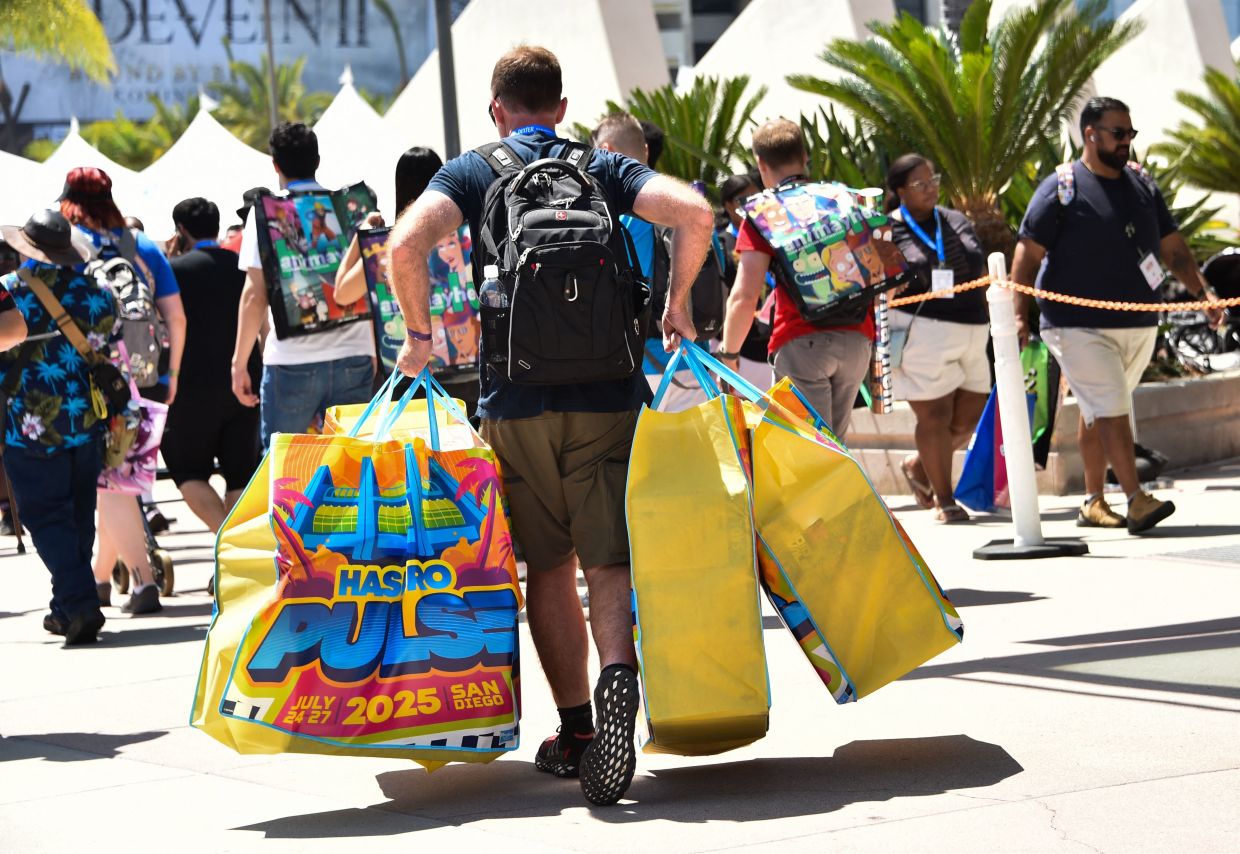 An attendee carries bags of items bought during Comic Con International in San Diego, California, on July 24. Photo: AFP