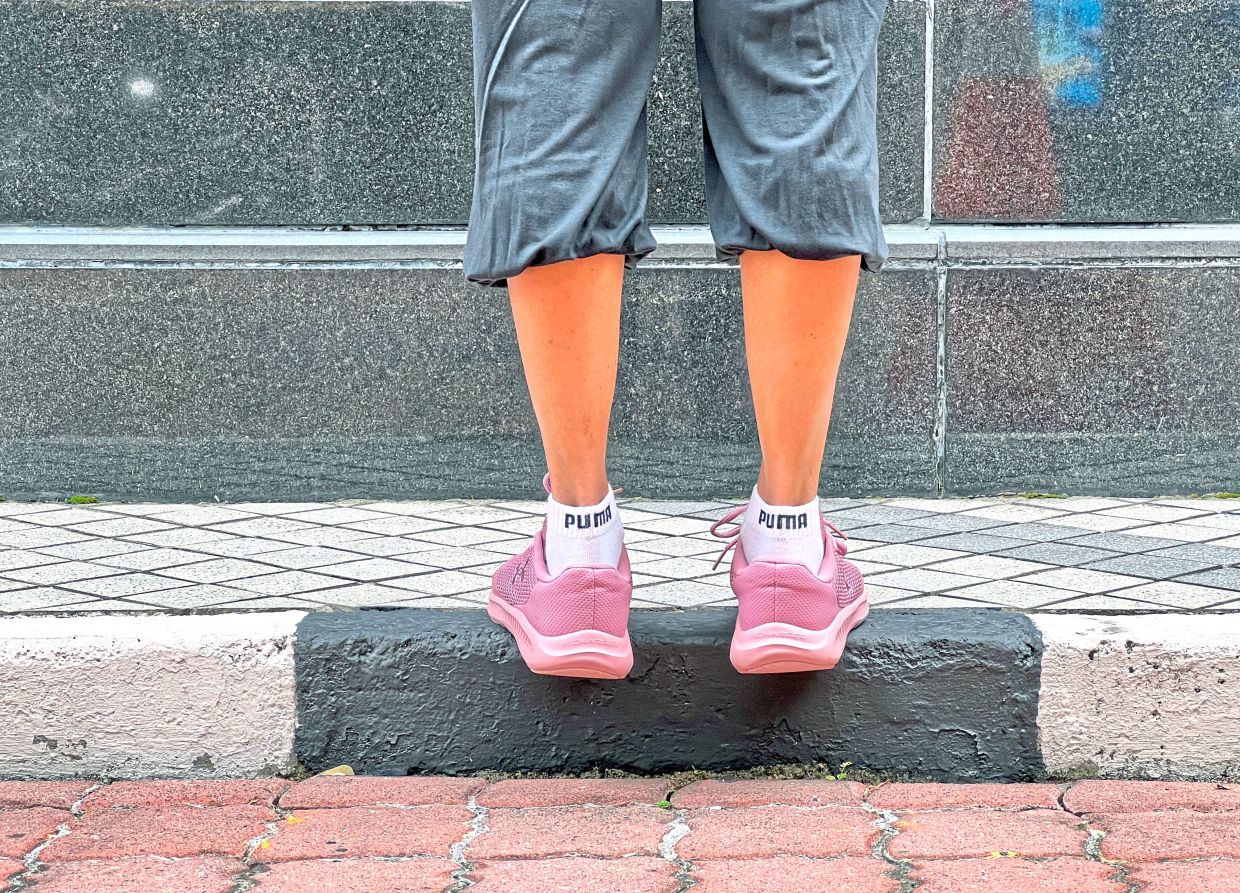 Stand on the edge of a step and if needed, use a wall to balance. — Photos: DARRAN TAN/The Star