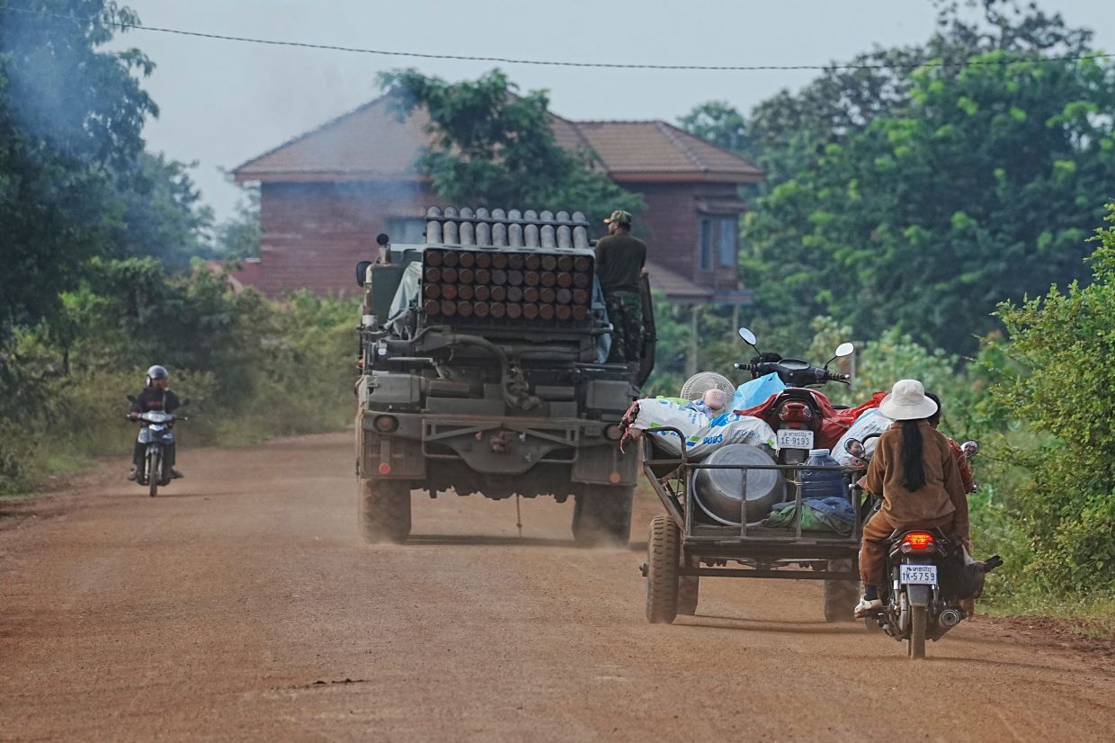 Cambodians driving behind a military vehicle for evacuation in Oddar Meanchey province, Cambodia on July 25, 2025. - AP