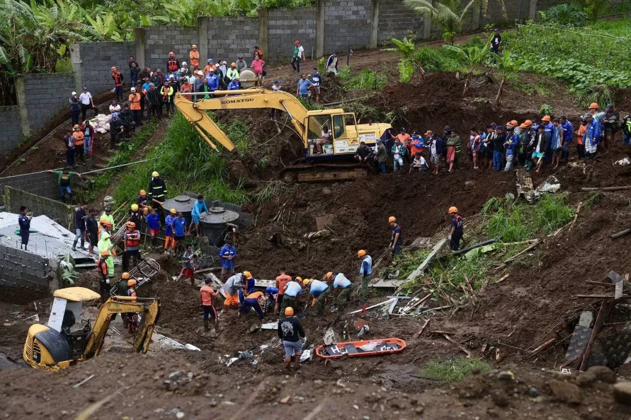 Policemen and personnel from the disaster response unit of Silang, Cavite, on Friday (July 25, 2025) retrieve one of two missing construction workers whose barracks were buried by a landslide that hit Barangay Iruhin West following heavy rains on Thursday. - Photo: Marianne Bermudez
