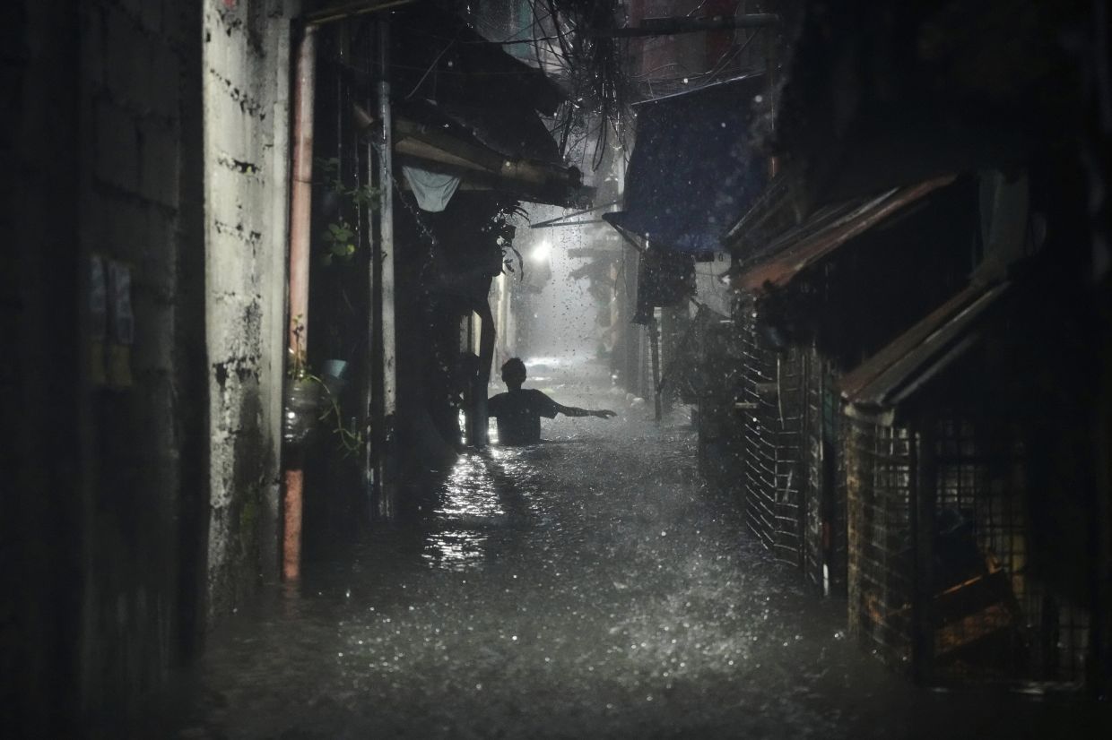 A man wades along waist-deep floods at a residential area afterTyphoon “Crising” (Wipha) caused intensified monsoon rains that bought flooding in Quezon city, Philippines, on Monday, July 21, 2025. - Photo: AP