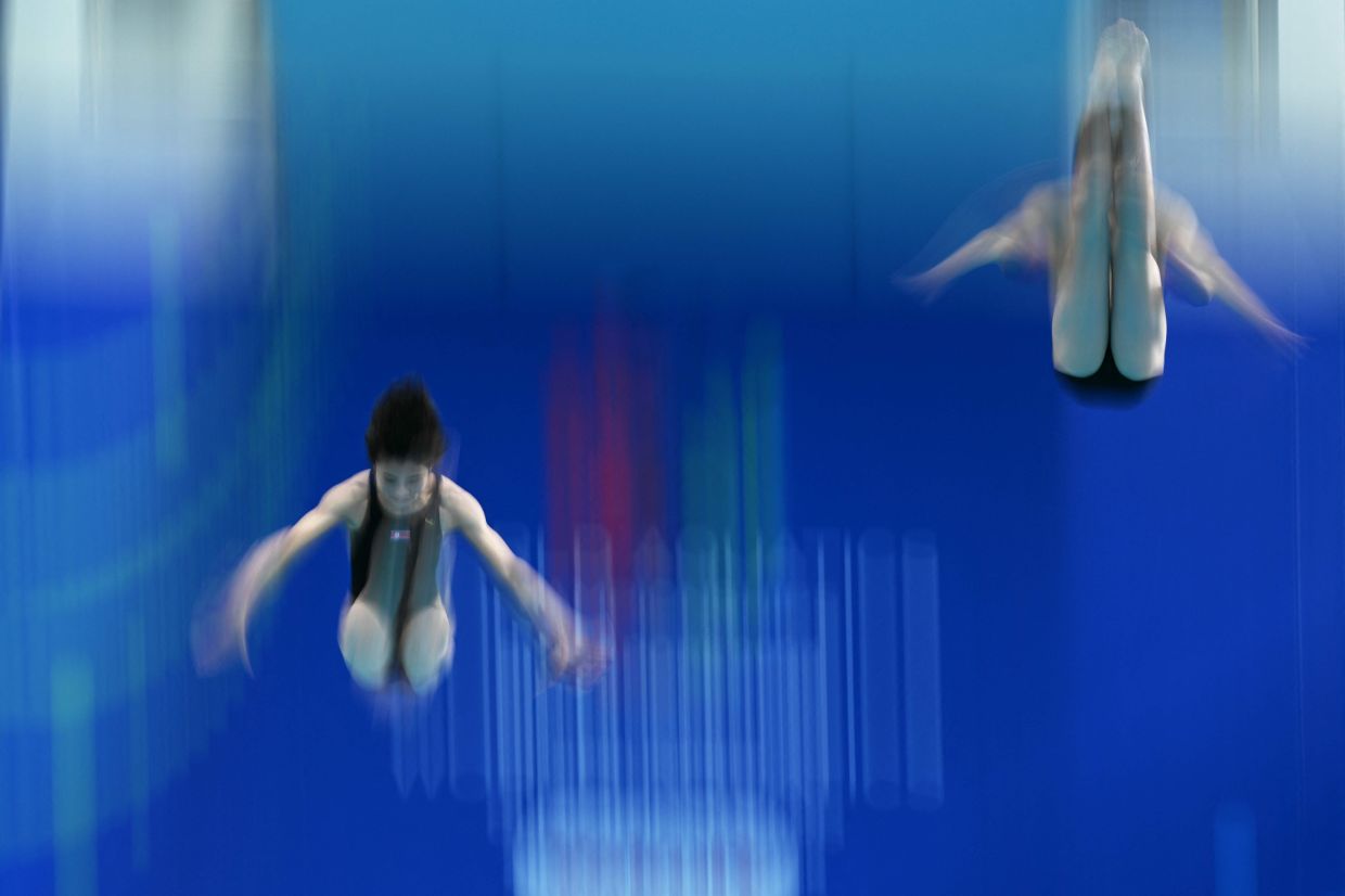 North Korea's Jo Jin Mi and Choe Wi Hyan compete in the final of the mixed team 3m and 10m diving event during the 2025 World Aquatics Championships in Singapore on Saturday, July 26, 2025. -- Photo by Oli SCARFF / AFP