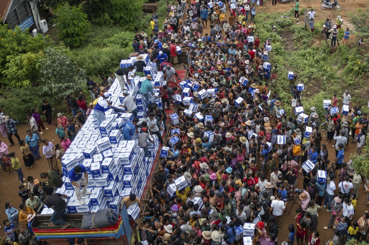 Displaced Cambodians receive water at the Battkhao Resettlement Camp in Oddar Meanchey Province, Cambodia, Saturday, July 26, 2025, as border clashes between Thailand and Cambodia entered its third day. -- AP Photo/Anton L. Delgado