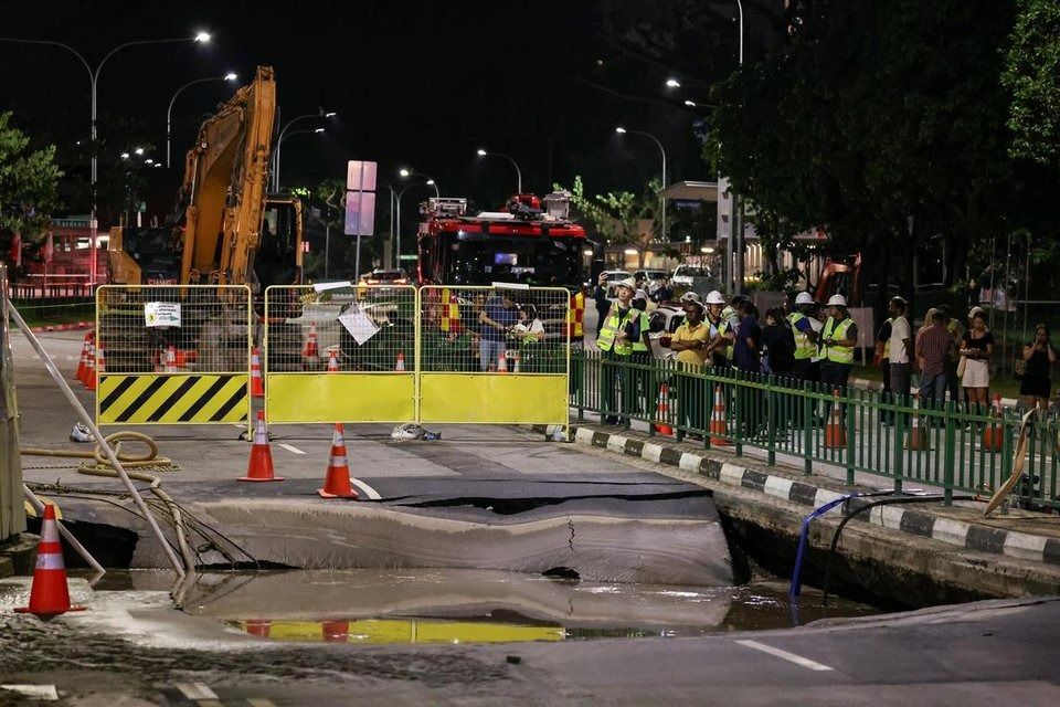 Water being pumped out of the sinkhole along Tanjong Katong Road South on July 26. - Photo: ST