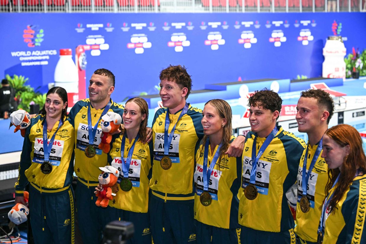 Gold medallists in the men's 4x100m freestyle relay swimming event Australia's swimmer Flynn Southam, Australia's swimmer Kai Taylor, Australia's swimmer Maximillian Giuliani and Australia's swimmer Kyle Chalmers, and gold medallists in the women's 4x100m freestyle relay swimming event Australia's swimmer Mollie O'Callaghan, Australia's swimmer Meg Harris, Australia's swimmer Olivia Wunsch, and Australia's swimmer Milla Jansen pose for a photo together during an awards ceremony at 2025 World Aquatics Championships in Singapore on Sunday, July 27, 2025. (Photo by MANAN VATSYAYANA / AFP)