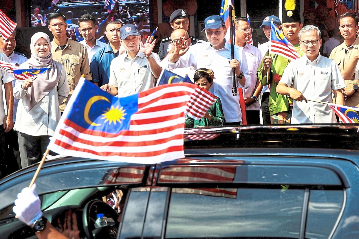 National pride: Anwar (fifth from right) flagging off a convoy for the launch of the 2025 National Month and Fly the Jalur Gemilang campaign at Dataran Tanjung Emas in Muar. Flanking him are Johor Mentri Besar Datuk Onn Hafiz Ghazi (fifth from left) and Communications Minister Datuk Fahmi Fadzil (right). — THOMAS YONG/The Star
