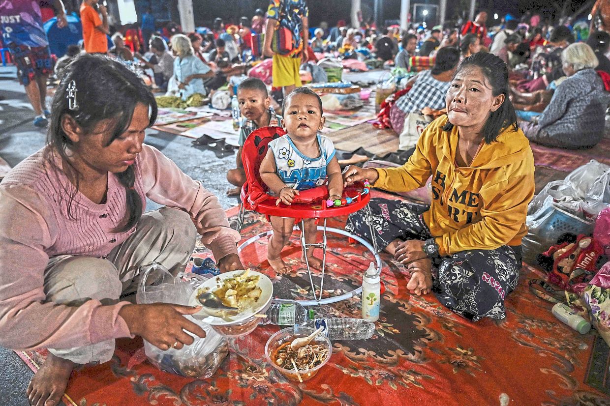 On the ground help: (Left) Evacuees displaced by the ongoing conflict between Thailand and Cambodia resting at an evacuation centre in the Thai border province of Sisaket while. — AFP