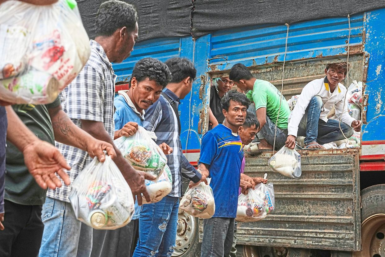 Local villagers help to unload supplies donated by a charity for refugees from a truck as they take refuge in Wat Phnom Kamboar, Oddar Meanchey province, Cambodia. — AP