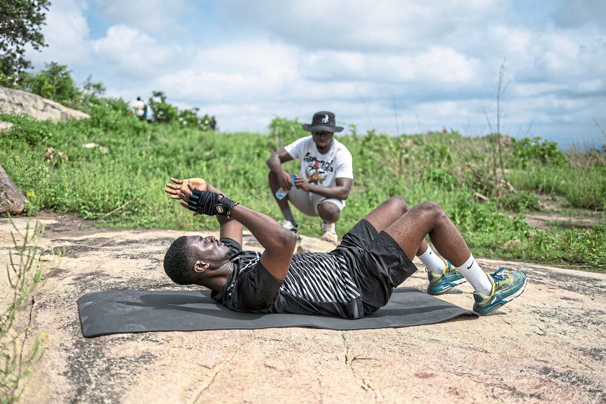A man performs abdominal exercises on a yoga mat.