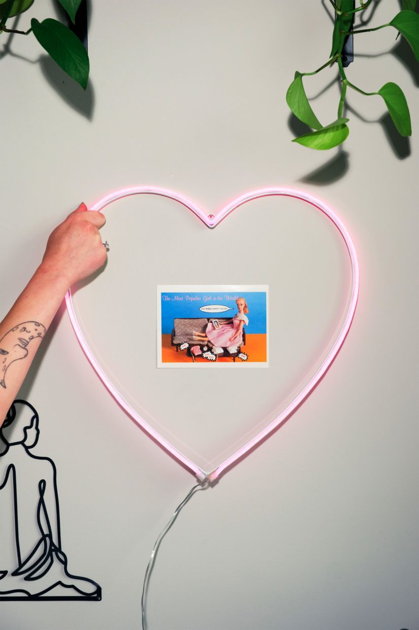 Lena Geller shows a neon heart light with an original retail of $117 that was left behind when Duke University students moved out of her apartment. — Photo: Cornell Watson/The New York Times)