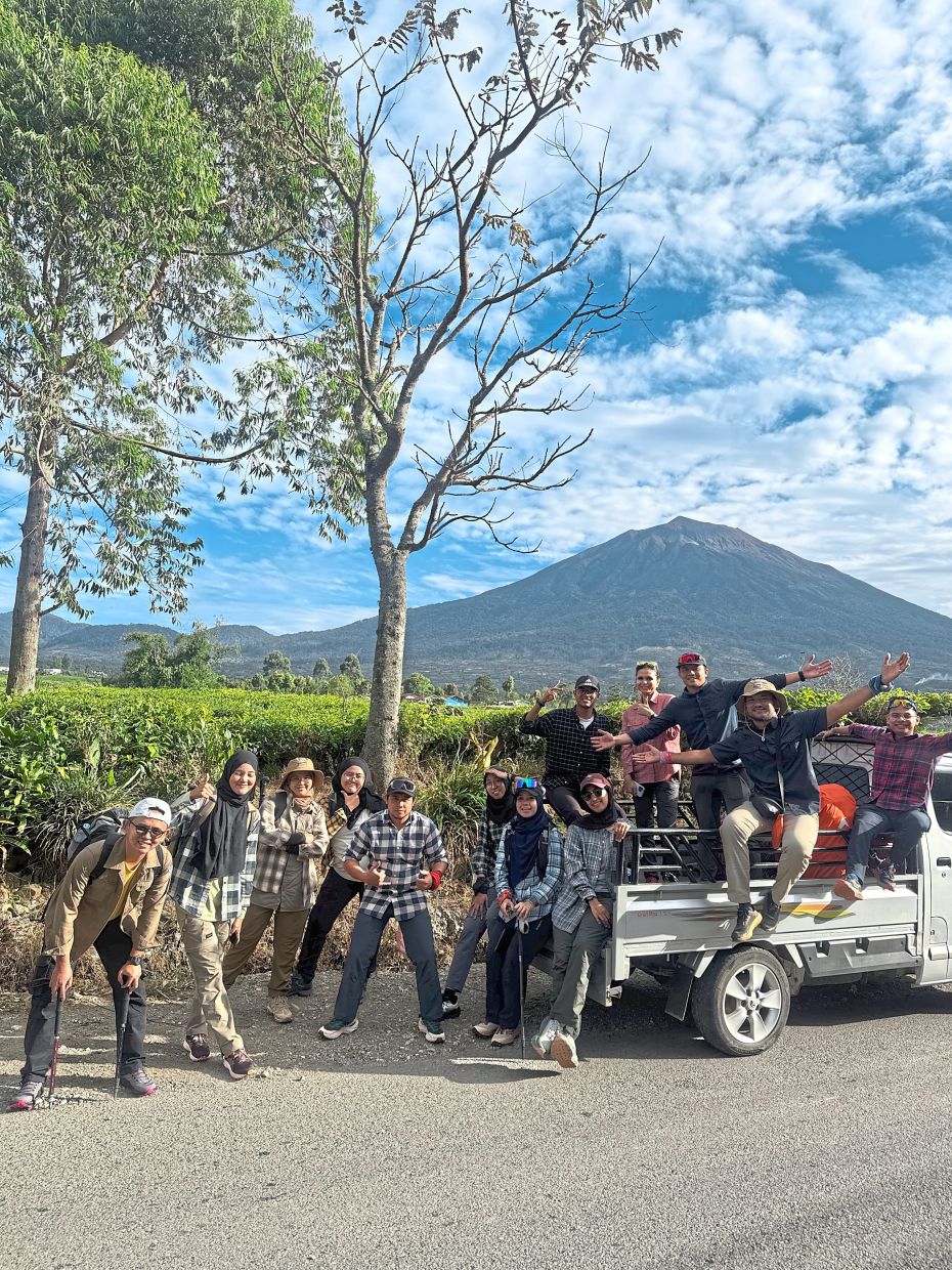 The group of friends and acquaintances before making the climb, with Mount Kerinci in the background.