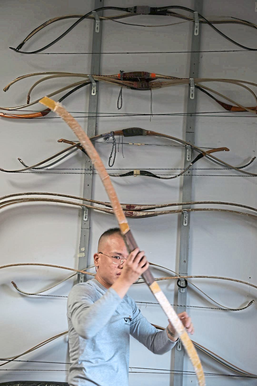 Wong selecting bow blanks to be shaped in his workshop.