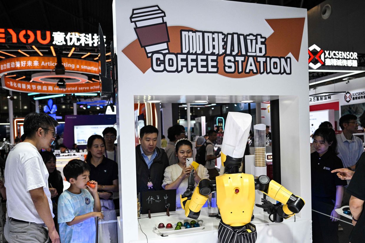 A robot prepares coffee in a stand during the World Artificial Intelligence Conference (WAIC) at the Shanghai World Expo and Convention Center in Shanghai on July 28, 2025. — AFP