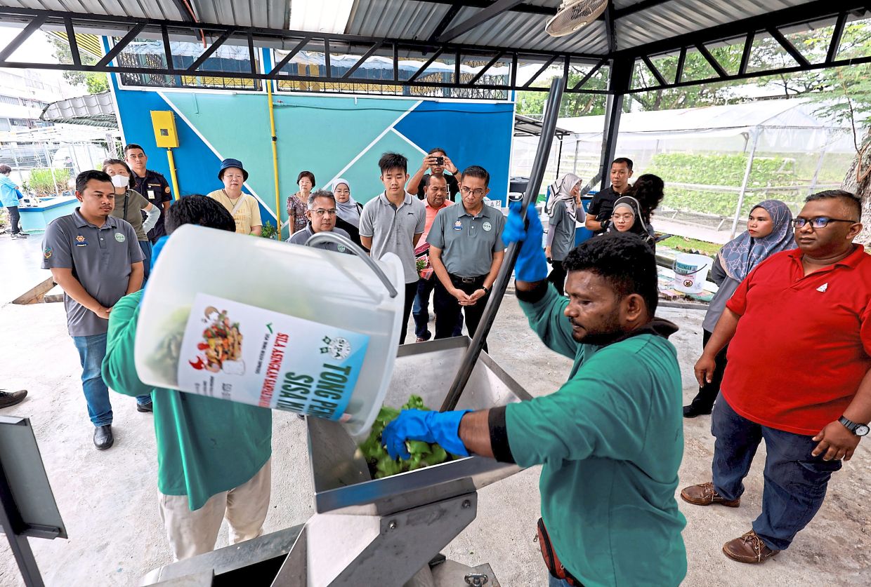 Visitors to the Smart Waste Solution Lab being shown how food scraps are ground.