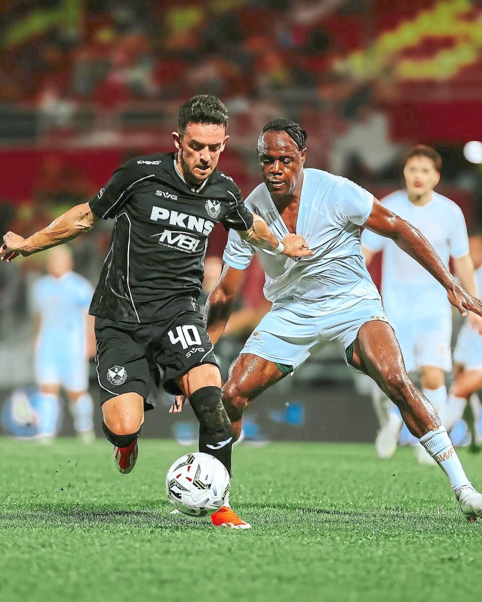 Tough battle: Zach Clough (left) vying for the ball with Asia Warriors’ Victor Igbonefo during a friendly match. — Selangor FC