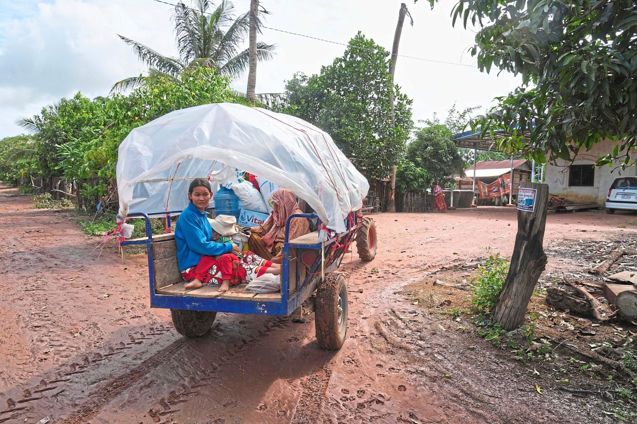 A Cambodian family returning home from a temporary shelter in Prasat Roboeuk village, Oddar Meanchey province. — Reuters/AFP