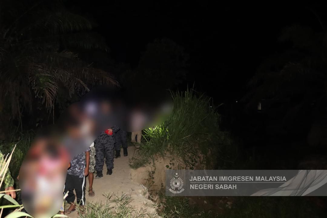 Illegal immigrants being detainedby Immigration officers following a raid in illegal settlements in Keningau.