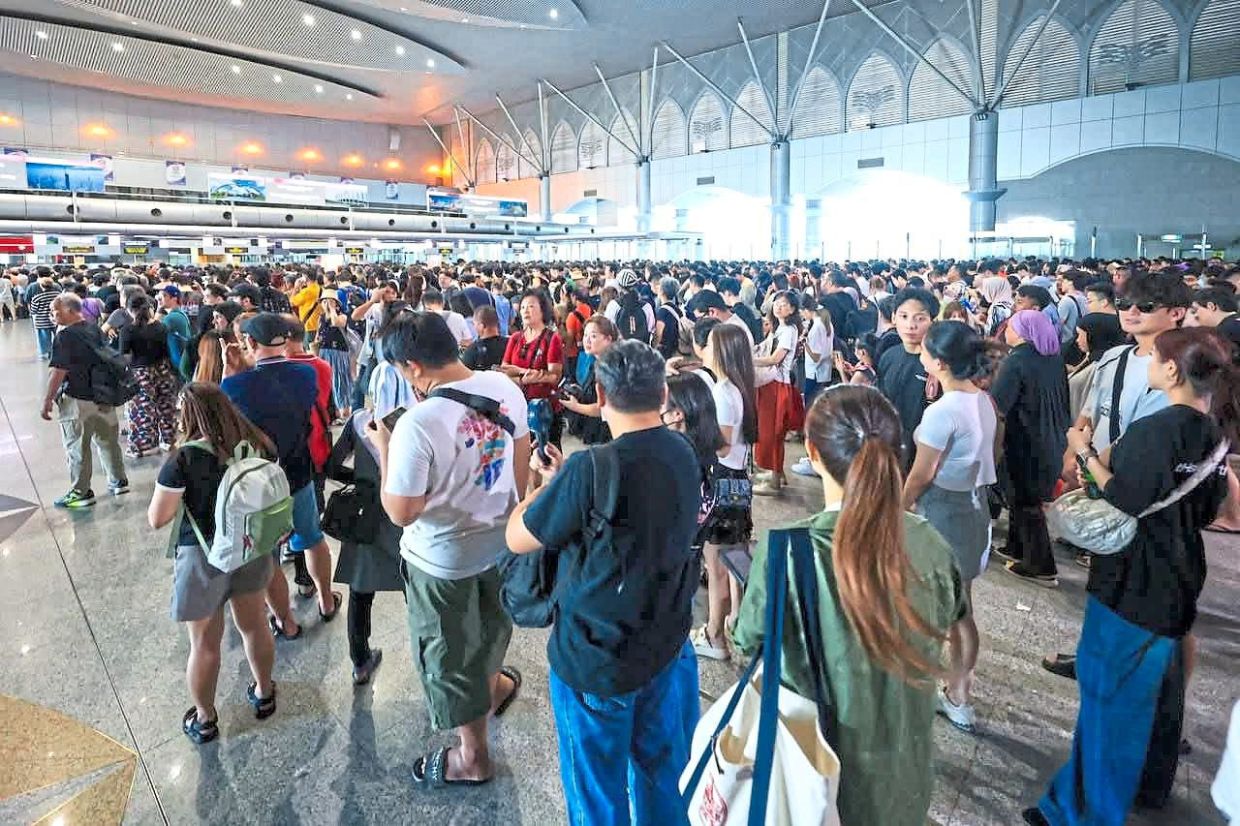 A large crowd waiting to clear immigration at Bangunan Sultan Iskandar CIQ on July 19 following the autogate system failure. — Filepic