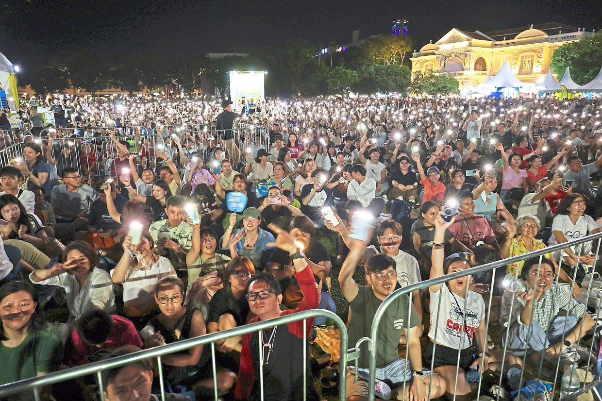 Locals and tourists enjoying the performance during the After Work Fest by 988 FM held at the Esplanade, Penang.( July 27, 2025 ) —CHAN BOON KAI/The Star
