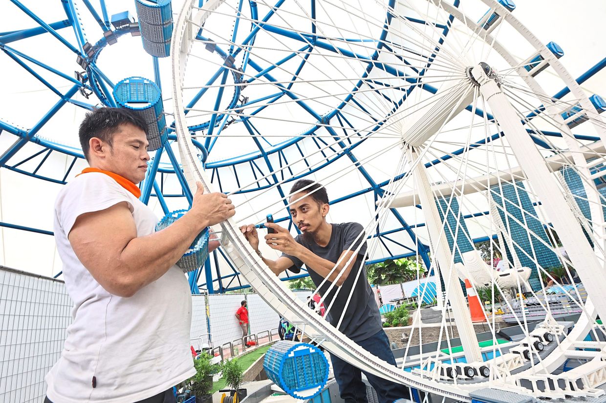 The Merlin Magic Making team installing a Singapore Flyer replica at Legoland Malaysia. — Photos: THOMAS YONG/The Star