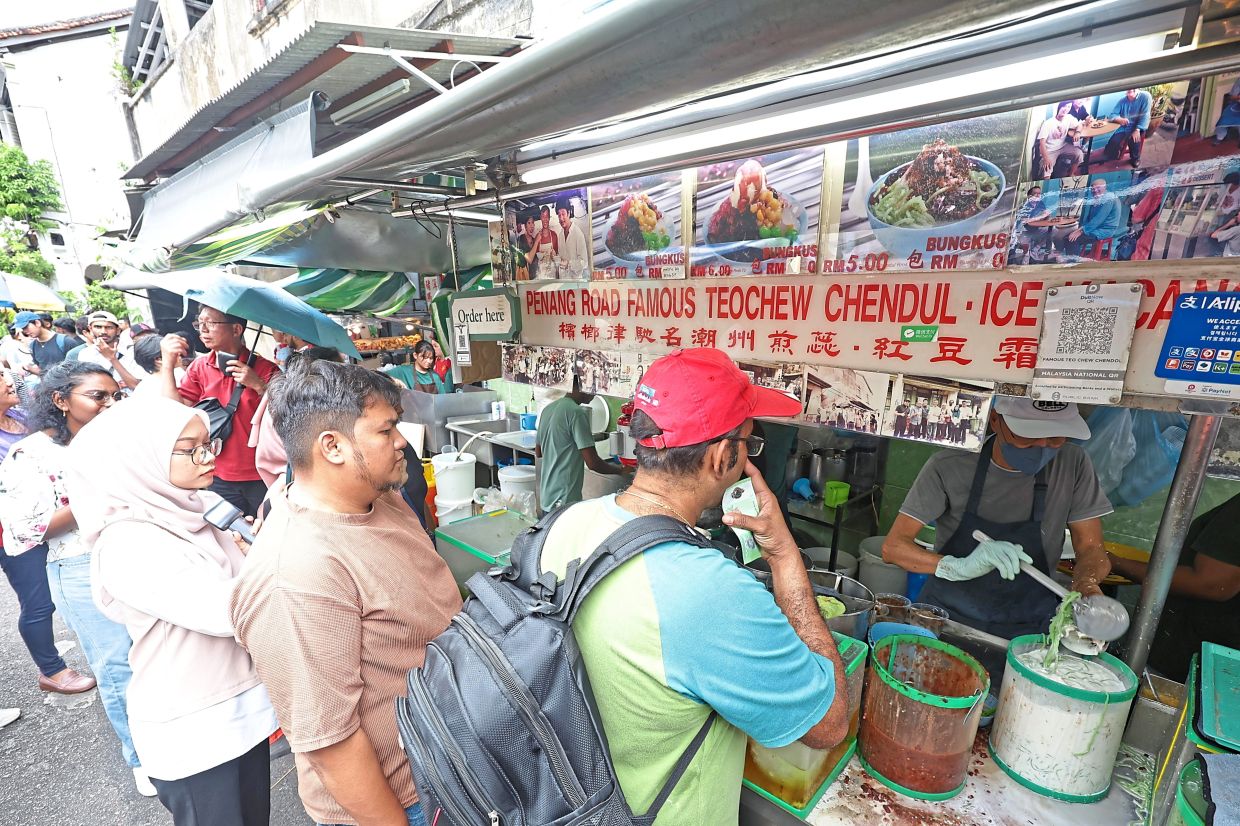 Sweet treats: Locals and tourists queuing up for the Teochew cendol and ais kacang at Penang Road. — CHAN BOON KAI/The Star
