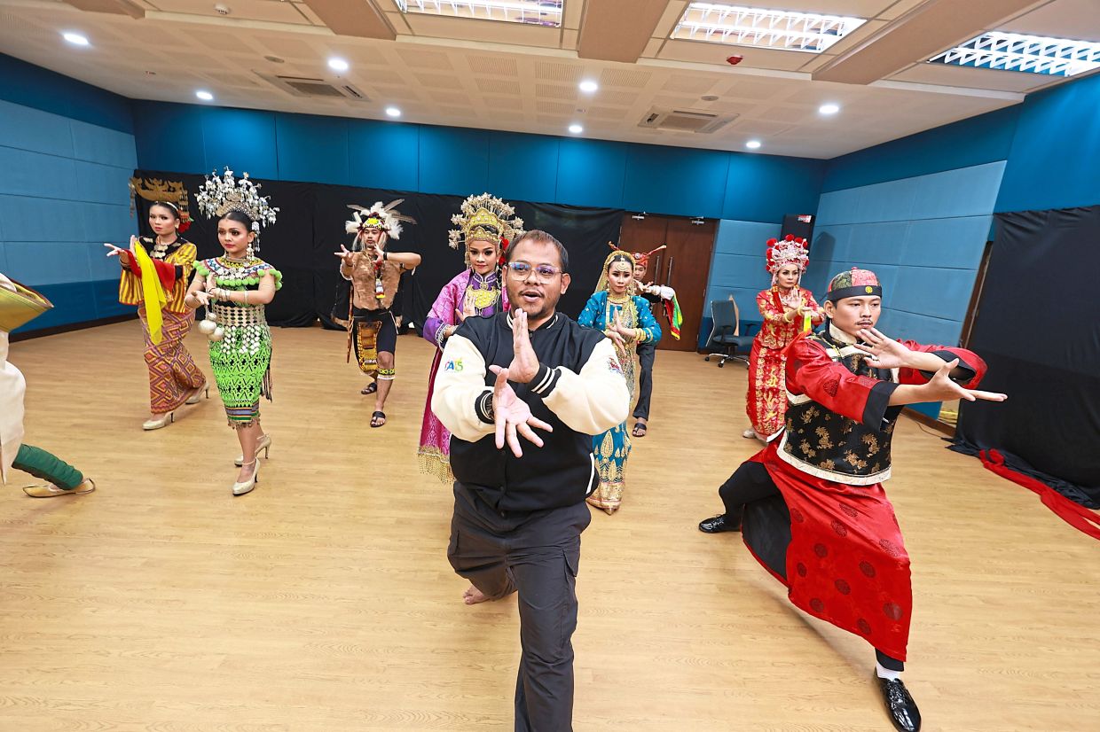 Mohamad Taufik (front) leading the DBKL troupe dancers through a dynamic routine during full dress rehearsals, blending traditional forms into a seamless celebration of unity.