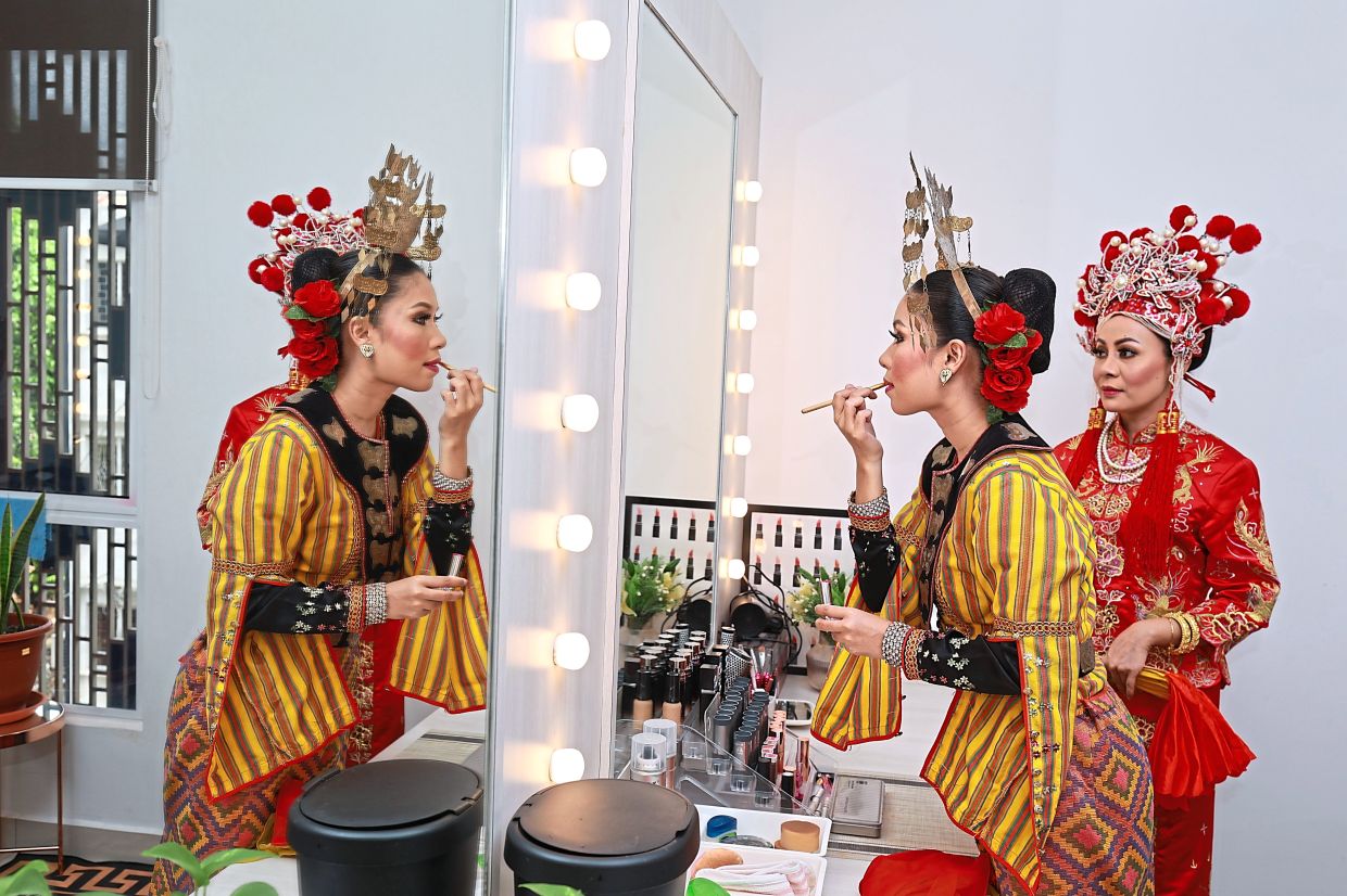 Dancers from the troupe preparing for a showcase, donning intricate costumes representing Malaysia’s rich ethnic heritage.