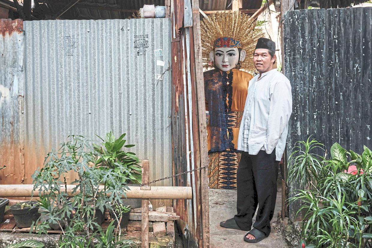 Ondel-ondel performer Fadillah, who recently performed at Japan’s Expo 2025 in Osaka, posing in front of his puppet warehouse. Photo: AFP 