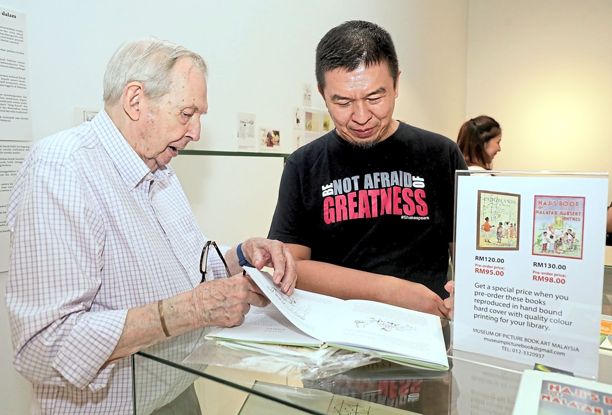 Duke (left) browsing the new reissues of 'Haji’s Book Of Malayan Nursery Rhymes' and 'Paddylands'. Photo: The Star/Samuel Ong 