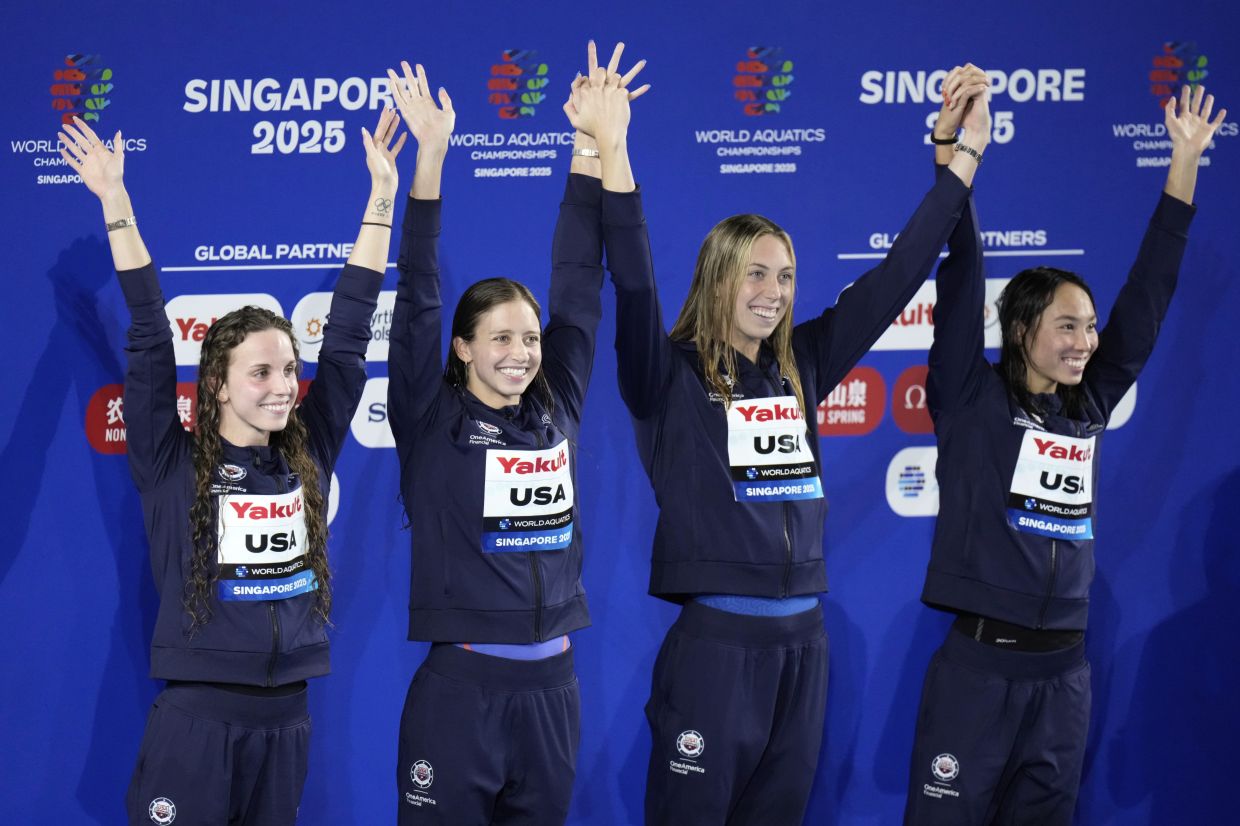 The gold medallist team United States, poses on the podium after the women's 4x100-meter medley relay final at the World Aquatics Championships in Singapore, Sunday, Aug. 3, 2025. -- AP Photo/Lee Jin-man