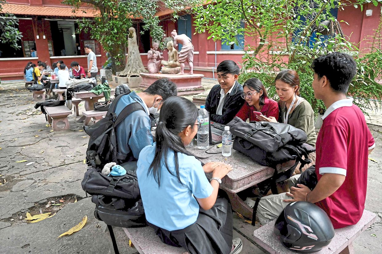 Building a future: Fine arts students doing assignments at their school in Phnom Penh. — AFP