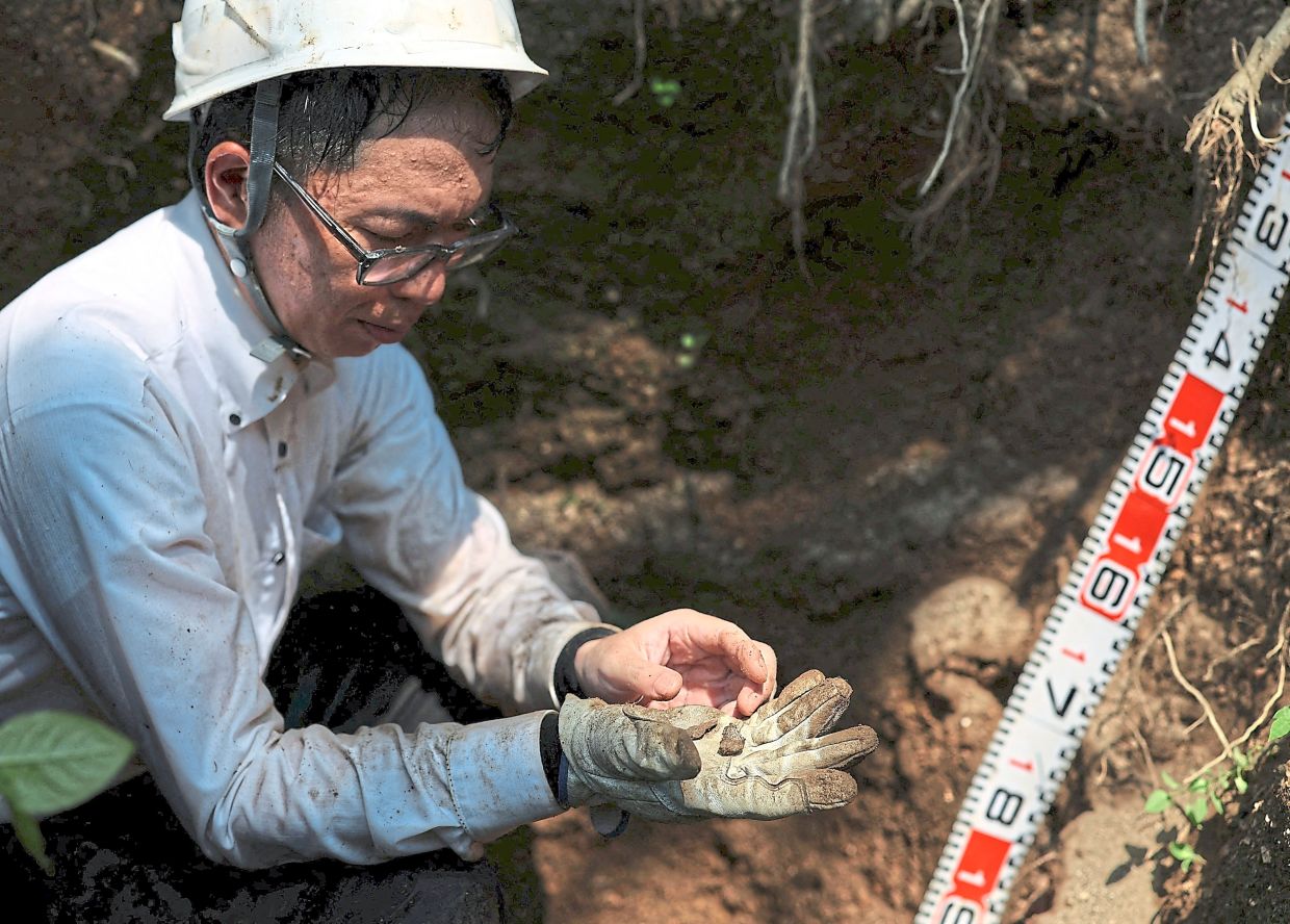 Showing the bone fragments which he found. — Reuters