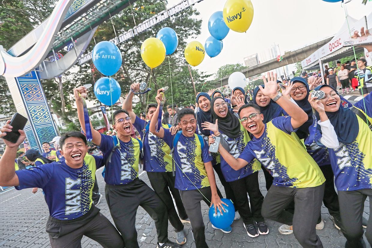 Happy faces of runners taking part in ‘Navy Run 25’ in conjunction with KL Car-Free Morning, which also sees a variety of activities, including horse-drawn carriage rides (below), on the streets of Kuala Lumpur.
