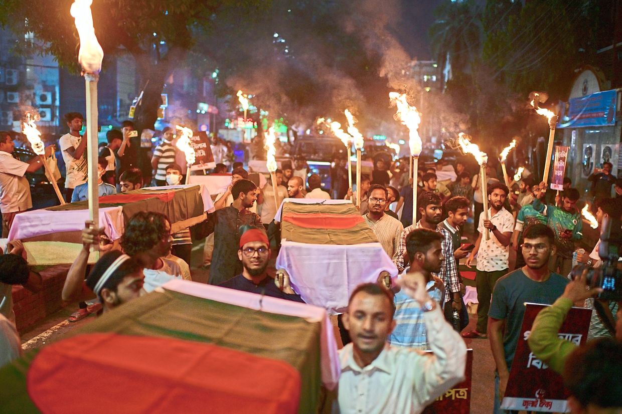 Activists carrying symbolic coffins and torches during a procession to mark the day of a student-led protest one year ago, in Dhaka, on July 16. — Reuters/AP