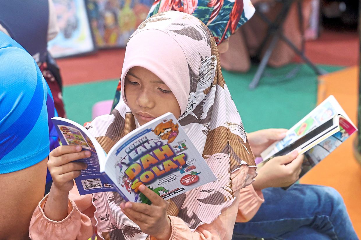 Two youths engrossed in their books during the bazaar held at a mall in Johor Baru.