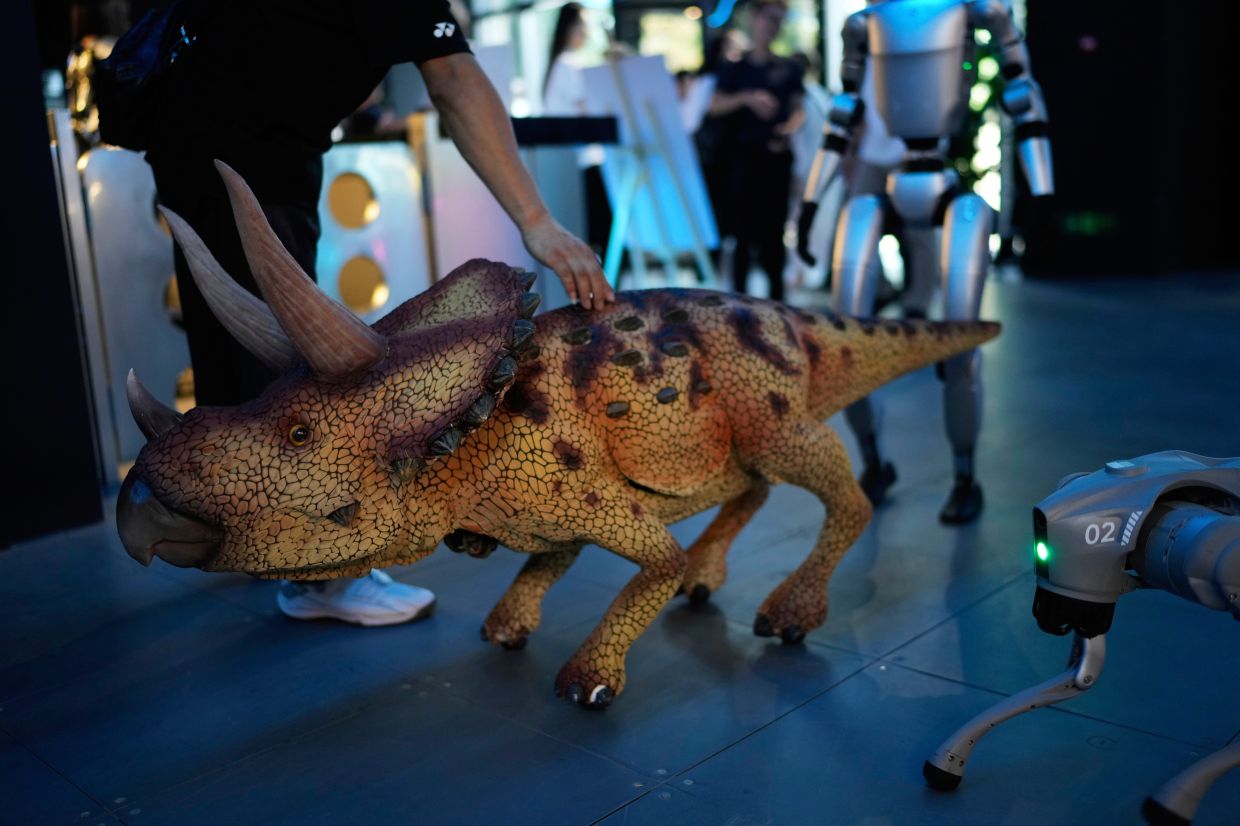 A visitor examines a dinosaur robot at the Robot Mall, said to be the world's first humanoid intelligent robot 4S store, in Beijing, China, on Aug 6, 2025. — AP