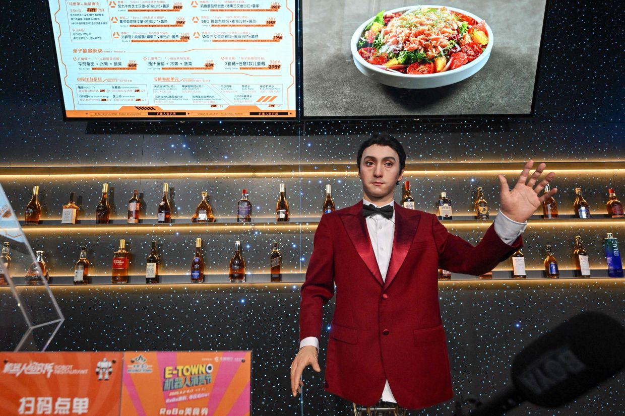 A robot takes a food order during a press tour at the Robot Mall in Beijing on August 6, 2025, ahead of the 2025 World Robot Conference that will be held from Aug 8 to 12. — AFP